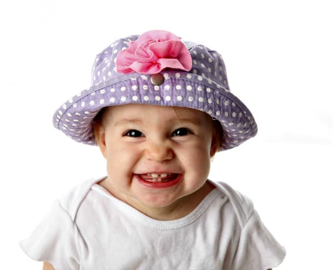 Cute toddler girl in polka dot hat with big smile for the camera