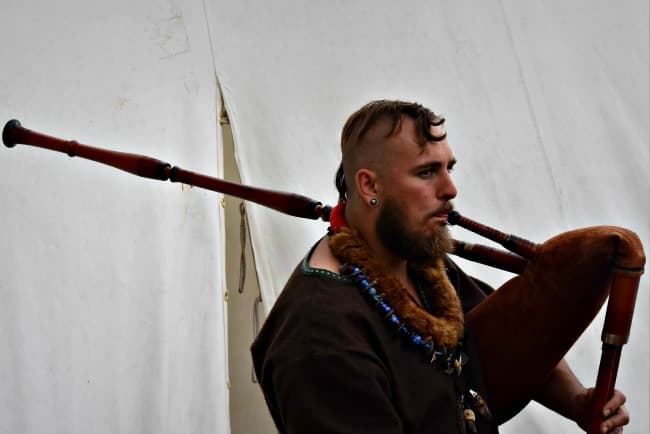 Man wearing Viking dress and playing bagpipes